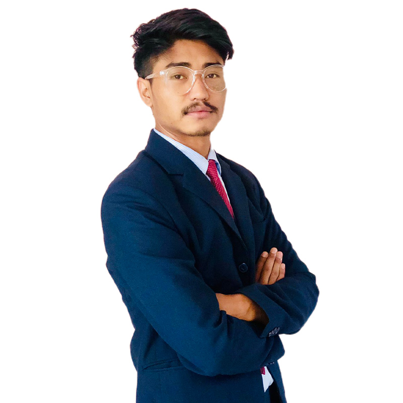 Professional headshot of Chham Bahadur Gurung, a confident developer wearing clear glasses and a navy blue suit with red tie, standing with arms crossed and a confident expression against a clean white background